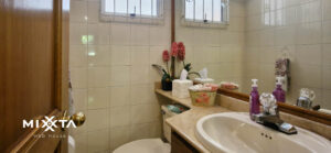 Fachada de casa atípica con doble techo a dos aguas y ventanas triangulares, ubicada en unidad cerrada en El Poblado, Medellín